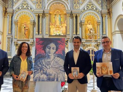 Torrevieja presenta el cartel anunciador de las Fiestas Patronales 2024 en honor a La Purísima. El cartel se centra en un plano medio de la imagen de La Purísima, teñido completamente en azul marino, sobre el que destaca en rosa la aureola de la Coronación Canónica